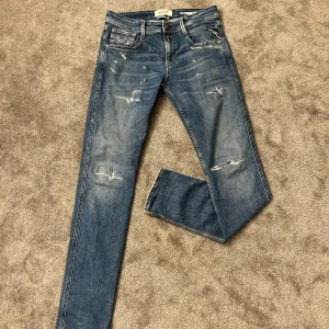 Replay anbass blå jeans - Säljer ett par Replay Anbass jeans med slitningar. Jeansen har en slim passform och funkar till alla olika tillfällen! Jeansen är bara använda ett par fåtal gångerHör gärna av er om ni har frågor.(priset är ej hugget i sten)