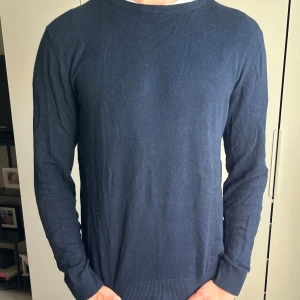 Mörkblå stickad tröja  - En enkel och stilren mörkblå stickad tröja med rund hals och långa ärmar. Perfekt för dig som gillar klassisk och clean stil. Storlek M. Modellen är 190cm, 78kg. Skriv om du har några frågor:)