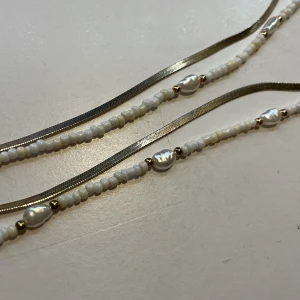Guld och pärl halsband - Super fint guld och pärlhalsband! Helt nytt och andvänt endast någon enstaka gång. Super fint och passar till allt! Fin guldfärg och fina vita pärlor på. Det är två halsband i ett! Pris kan diskuteras. Skriv privat vid fler frågor! 💕