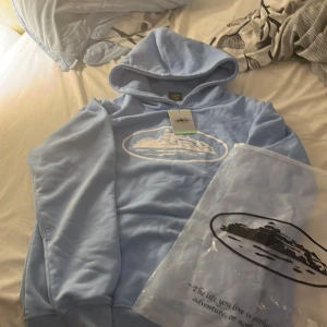 Corteiz hoodie ”Baby Blue” - Hoodie från Corteiz som är köpt för typ ett och ett halvt år sedan. Jag har haft på mig hoodien typ 6 gånger, så den är nästan i nytt skick. Priset går absolut att förhandla, jag är öppen till alla förslag så de e bara att skicka priset du vill ha den för och så får vi se hur de blir. Storleken är M och sitter lite baggy på mig som är 180 cm.