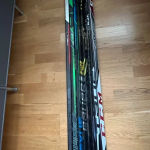 7 hockey klubbor - Bilderna visar ett set med hockeyklubbor, flera olika modeller och märken. Klubborna har tydligt använts, med tejpade och slitna blad. Perfekt för träning eller hobbyspelare som söker prisvärda klubbor. Inga synliga sprickor, men normalt slitage förekommer.