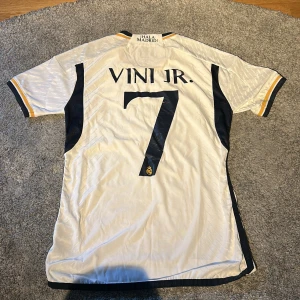  Vini Jr. tröja -  officiell Real Madrid fotbollströja med Vini Jr. med nummer 7 på ryggen.