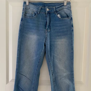 Blå jeans med broderade bakfickor Shein - Snygga blå jeans från Shein i storlek S med broderade detaljer på bakfickorna och klassisk femficksdesign. Jeansen har normal passform och är tillverkade i bomullsmix med lite stretch. Perfekta för en avslappnad och trendig look.