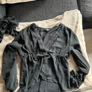 Svart blus   - Svart blus från SHEIN. Tröjan är långärmad  med v-ringning dekorerad med spets. 