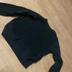 Svart sweatshirt från 157 - En basic svart sweatshirt från 157 med rund hals och långa ärmar. Tröjan är i mjukt material och har en klassisk passform som funkar till det mesta. Perfekt att slänga på sig när det är lite kyligare ute.