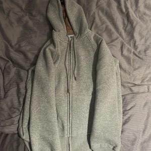 Grå Burberry hoodie med dragkedja - Snygg grå hoodie från Burberry med klassiskt rutigt foder i huvan.  Skick 10/10 , var förliten när jag fick den, storlek s men passar mer xs. Snabb affär sänks priset