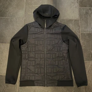  J.Lindeberg hybridjacka - J.lindeberg hybridjacka i storlek m. I  i Mycket fint skick, inte mycket använd. Färg svart. Skriv gärna vid funderingar 