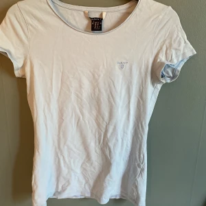 Ljusblå t-shirt från GANT i bomull - Fräsch ljusblå t-shirt från GANT med broderad logga på bröstet. Klassisk rund hals och korta ärmar, tillverkad i mjuk bomull. Perfekt för dig som gillar stilrena och enkla plagg med diskreta detaljer.