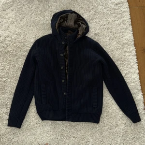 Stickad cardigan jacka  - Mörkblå stickad cardigan jacka från Ferrante i storlek 50, men sitter som en M. Nypris ligger på runt 7000. Är nästan i nyskick då den knappt är använd. Vid funderingar skicka gärna ett DM! 🙌