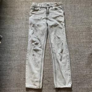 Grå jeansbyxor från RYVLS - Snygga grå jeansbyxor från RYVLS i rak modell. Klassisk femficksdesign med dragkedja och knapp framtill. Jeansen har en ljusgrå tvätt och raka ben, perfekta för en avslappnad och stilren look.
