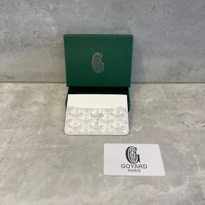  Goy4rd plånbok - En vit plånbok från Goy4rd med deras ikoniska grafiska mönster och logga framtill. Snygg design med flera kortfack, perfekt för dig som vill ha stilren och lyxig accessoar i väskan eller fickan. Kommer i original grön ask. För frågor eller fler bilder är de bara att skriva. Pris kan diskuteras!