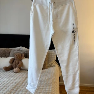 Vita mjukisbyxor Sail Racing M - Vita mjukisbyxor från Sail Racing i storlek M. Byxorna har snörning i midjan, fickor på sidorna och svart Sail Racing-logga längs ena benet. Tillverkade i mjukt bomullsmaterial för en chill och sportig vibe.
