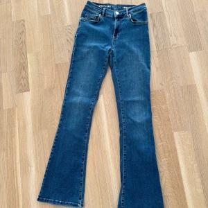 Flare, blue wash jeans, BikBok - Säljer dessa snygga medel mörk blåa jeans i stretchigt material från BikBok då de ej kommer till andvänding lägre. Jeansen passa enig som är 160cm💕jeansen är en del använda, därav priset (se 2 sista bilderna). Defekterna på bakfickan går att sy ihop💕