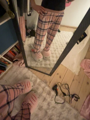 Rosa rutiga mjukisbyxor XS - Säljer ett par rosa mjukisbyxor med blått och vitt rutmönster. Byxorna har resår i midjan och är gjorda i mjukt material med 95% polyester och 5% elastan. Perfekta för chill dagar hemma eller sleepovers.