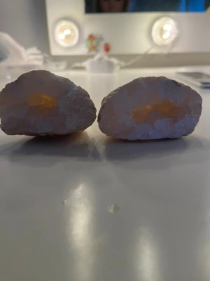 Ingen väst – kristallgeoder säljes - Bilderna visar två halvor av en kristallgeod med vit och lätt gulaktig insida. Ytan är rå och stenig medan insidan glittrar av små kristaller. Perfekt som dekoration eller samlarobjekt.