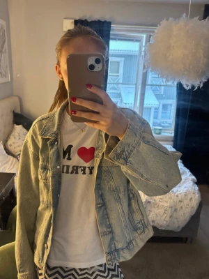 Ljusblå jeansjacka med klassisk look - Säljer en ljusblå jeansjacka med klassisk passform och snygga sömdetaljer. Jackan har knappar framtill, två bröstfickor och en tidlös design som passar till det mesta. Perfekt för dig som gillar en avslappnad och trendig stil.