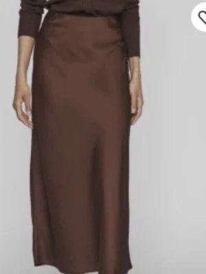 Brun satinkjol från NA-KD - PRISLAPP KVAR!!Nypris 399kr! As najs kjol till sommar och höst! Säljer en lång, brun satinkjol från NA-KD. Kjolen har en mjuk glansig finish och en enkel, stilren design som faller snyggt längs benen. Perfekt att styla med både stickad tröja eller topp. Kjolen har en lätt utställd form och är superenkel att matcha.