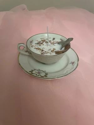 Doftljus i vaniljdoft i en vit tekopp med blommor på nr 3 - Det här ljuset är gjort av återanvändbara material. Tekoppen är köpt secondhand och stearinet är från kyrkor som tänkte slänga det. Det här ljuset har en svag doft utav vanilj, så känsliga även kan använda det. Det här ljuset har även torkade blommor på som dekoration. Det finns fler av denna design på hemsidan om man vill köpa sets. 