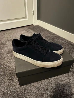Mörkblå sneakers från Vagabond - Snygga mörkblå sneakers från Vagabond i mocka med vita sulor och klassisk snörning. Skorna har en stilren och enkel design som passar till det mesta. Perfekta för dig som gillar en clean look med lite extra edge.