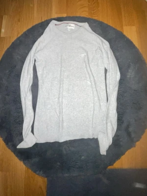 Ljusgrå långärmad tröja Morris - En stilren ljusgrå långärmad tröja från Morris. Tröjan har en klassisk passform och är tillverkad i mjuk bomull. Diskret Morris-brodyr på bröstet. Perfekt till jeans eller kjol för en clean look.