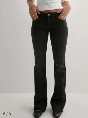 Svarta flared jeans från ONLY - Snygga svarta jeans från ONLY med bootcut och klassisk femficksdesign. Jeansen har en låg midja och i nytskick använda max 4-5 gånger. Perfekta att matcha med sneakers eller boots för en cool look. Säljer dem vidare då de är för korta för mig 