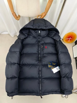 Svart pufferjacka från Polo Ralph Lauren - Säljer en svart pufferjacka från Polo Ralph Lauren med huva och dragkedja framtill. Jackan har en röd broderad logga på bröstet, flera fickor med dragkedja och justerbara detaljer vid ärmslut och nederkant. Perfekt för kalla dagar och riktigt snygg streetstil.