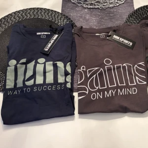  MM Sports t-shirts - Tre snygga t-shirts från MM Sports i storlek L. En mörk grå med vit text 'gains on my mind', en med svart glansig text och en marinblå med ljus text 'lifting way to success'. Alla är kortärmade och i mjuk bomull, perfekta för gymmet eller chill.Helt nya och oanvända!Köp alla tre för 400:- 