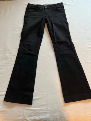 Jeans från Only - Svarta, utsvängda, lågmidjade jeans från Only i storlek S/32. De är uppsydda så de passar någon som är runt 160. Fint skick och inte särskilt använda! Innerbenslängden är 73 cm och midjemåttet mätt rakt över är 37 cm💕
