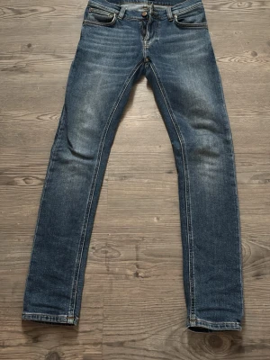 Blå skinny jeans från Nudie Jeans - Säljer ett par klassiska blå skinny jeans från Nudie Jeans. Aldrig använda och är i super bra skick! Säljer för att dem är för små för mig. Pris kan diskuteras. Hör gärna av er vid fler frågor och funderingar! Storlek 28/30