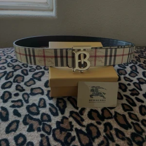 Burberry bälte  - Säljer nu detta snygga Oanvända bälte från Burberry med klassiskt rutigt mönster i beige, svart och rött, bältet är 110 cm och är ej använt (helt nytt) finns också kvitto 🧾 otroligt perfekt för att lyfta vilken outfit som helst. Vid intresse eller vid eventuell flera bilder bara att höra av sig!