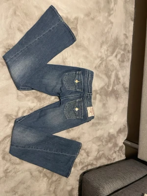 True Religion  - Säljer ett par blå True Religion Joey Low Rise Flare jeans.    Använd någon gång men inte mycket, bra skick förutspå en liten slitning längs ner finns bild annars jätte bra skick    Storlek 25 