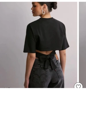 Svart topp med knyt - (Xxs men sitter som xs)svart croppad topp från Nelly med korta ärmar och snygg knytning i ryggen. Materialet känns mjukt och bekvämt mot huden. Använd några gånger