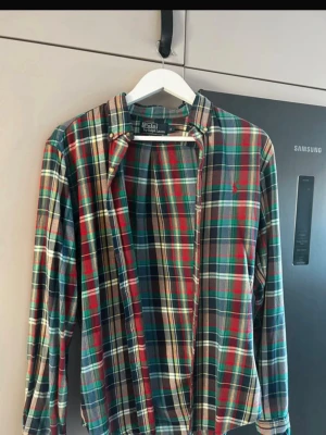 Rutig skjorta från Polo Ralph Lauren - Säljer en slim fit skjorta från Polo Ralph Lauren i storlek S. Skjortan har ett klassiskt rutigt mönster i grönt, rött, blått och beige. Hör av dig vid minsta fråga!