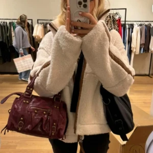 Beige teddyjacka med bruna detaljer - Säljer en beige teddyjacka med bruna detaljer längs dragkedjan och ärmarna. Jackan har hög krage, två fickor framtill och en oversized passform. Materialet är mjuk fleece som ger en mysig vibe. Perfekt för dig som gillar chill och comfy stil.
