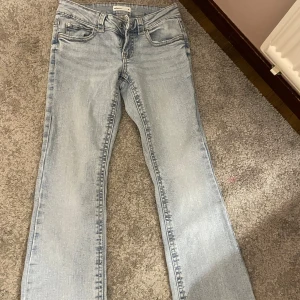 Ljusblå botcutjeans från Gina Tricot - Dom är uppsydda. Säljer ett par ljusblå 'perfect jeans' från Gina Tricot i storlek 34. Jeansen har klassisk femficksdesign, raka ben och snygga detaljer på bakfickorna med knappar. Perfekt tvättad look och normal passform.