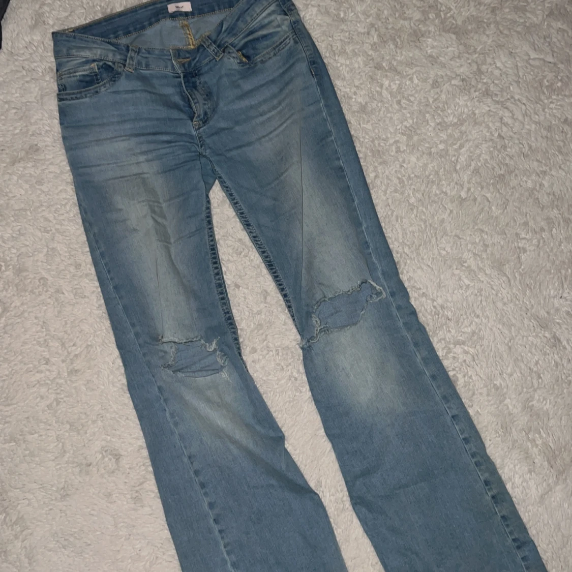 Ljusblå jeans med slitna knän från Nelly