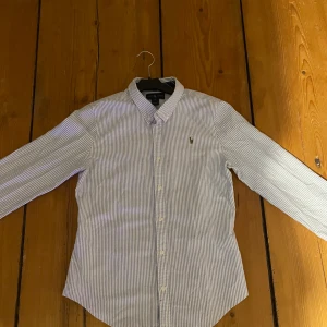 Randig skjorta från Ralph Lauren - Riktigt snygg Ralph lauren skjorta. Det är storlek 16y och passar dig om du är cirka 170. Bra skick. Kostar cirka 1100 ny. Skriv ifall du har några frågor eller vill ha måtten på skjortan.