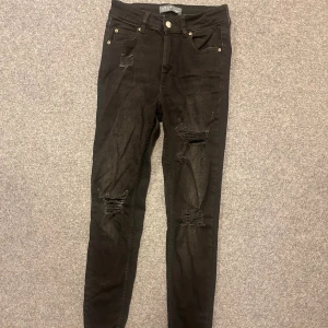 Svarta skinny jeans med slitningar - Svarta skinny jeans från Zara med snygga slitningar på låren och knäna. Klassisk femficksmodell med dragkedja och knapp. Perfekta för en trendig och avslappnad look.