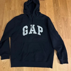 Svart hoodie från GAP i storlek L - Säljer min svarta GAP tröja som jag inte använder. Nytt skick utan hål eller slitage. Säg ett pris och så ser vi 