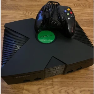 Microsoft Xbox Launch Edition 8GB Home Console - Black - Den här gamla pärlan är fullt fungerande och startar som den ska. Moddat (chippad) Xbox med över 50 spel förinstallerade direkt på hårddisken, så du kan spela utan skivor. Innehåll: Xbox (PAL-version) 1 original handkontroll, fungerar fint men är välanvänd Alla originalkablar (ström + bild) Info: Startar upp utan problem Xbox Media Center installerat (ny dashboard) DVD-läsaren är urkopplad eftersom den krånglade, men allt fungerar perfekt via hårddisken. Öppen för rimliga bud, Inga skam bud! 