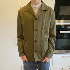Massimo dutti overshirt  - En riktigt snygg olivfärgad lite tjockare overshirt från Massimo dutti. Med en snygg passform är denna perfekt till lite kyligare tillfällen. Skick 9/10 inga synliga defekter, enda defekten är att taggen sitter lite löst. Har du några frågor kring mått osv? Fråga på!