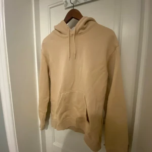 Beige hoodie från H&M XS - Säljer en beige hoodie från H&M i relaxed fit, storlek XS. Tröjan har huva med snörning och en stor magficka framtill. Perfekt för chill dagar och enkel att matcha med jeans eller mjukisbyxor.