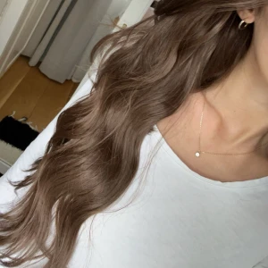 Vågig hårförlängning LullaBellz - Clip-in hårförlängning från LullaBellz i färgen Chestnut, längden är 22 inch (55cm) tillverkad av syntetiskt silkesfiber. Totalt 5 delar i paketet, perfekt för att få extra volym och längd på nolltid! Helt oanvänd endast testad.