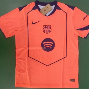 Barça orange matchtröja - FC Barcelona fotbollströja i orange med lila/blå detaljer och tryck. Nike-logga, klubbmärke och Spotify-sponsor på bröstet. UNHCR-tryck på ryggen. Kortärmad modell i lätt och ventilerande material, perfekt för match eller träning. Ej officiell!!!