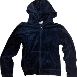 Mörkblå Juicy Couture kofta - Säljer en mörkblå hoodie från Juicy Couture med huva och dragkedja framtill. Tröjan har långa ärmar och två fickor på magen.