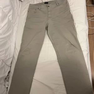 Beige raka byxor från Park Lane - Snygga beige byxor från Park Lane med klassisk femficksdesign och raka ben. Byxorna har normal passform och är tillverkade i ett mjukt bomullsmaterial som känns skönt mot huden. Perfekta för dig som gillar stilrena och enkla plagg.