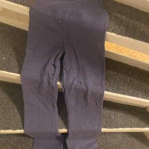 Mörklila stickade leggings Gina Tricot - Mörkblå stickade leggings från Gina Tricot i storlek 158/164. Byxorna har ribbad midja och är gjorda i ett mjukt, stickat material som sitter tight och bekvämt. Perfekta för dig som gillar en chill och snygg stil.