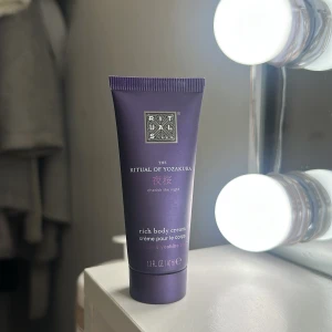 Rituals The Ritual of Yozakura body cream - En lyxig body cream från Rituals i serien The Ritual of Yozakura. Tuben är mörklila med silverdetaljer och innehåller 40 ml. Doft av ris och yoshino körsbär. Perfekt för att återfukta huden och ge en mjuk känsla. Använd några gånger men mer än halva i. 