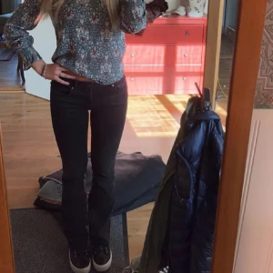 Svarta bootcut jeans från Zara - Säljer ett par svarta jeans från Zara i storlek 38. Jeansen har bootcut-modell med lätt utsvängda ben och klassisk femficksdesign. De är lågmidjade och tillverkade i ett mjukt bomullsmaterial med lite stretch för extra komfort.