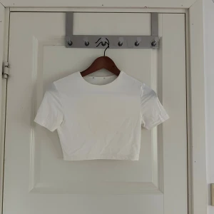 Vit croppad t-shirt topp Zara - En stilren vit croppad topp med korta ärmar och rund halsringning från Zara 🤍